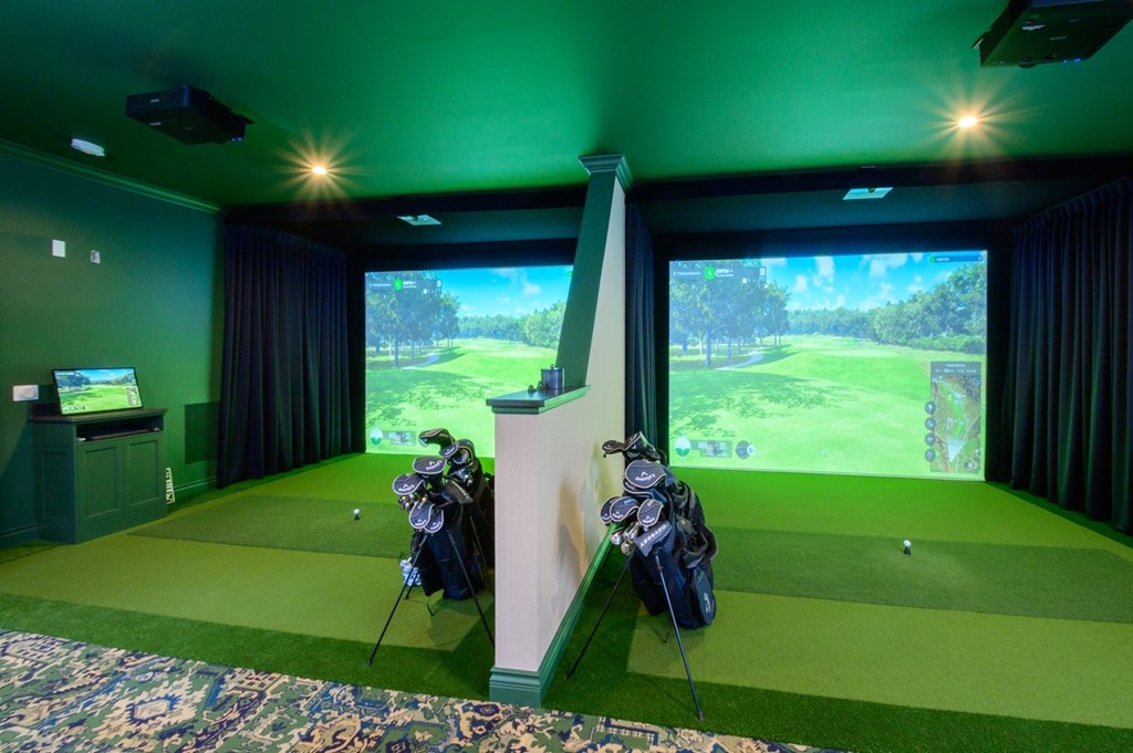 A golf simulator room with a screen showing a golf course.