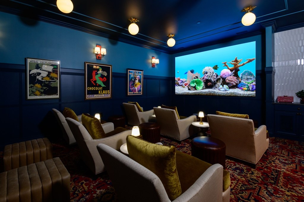 A room with a blue wall and a screen showing a cartoon.