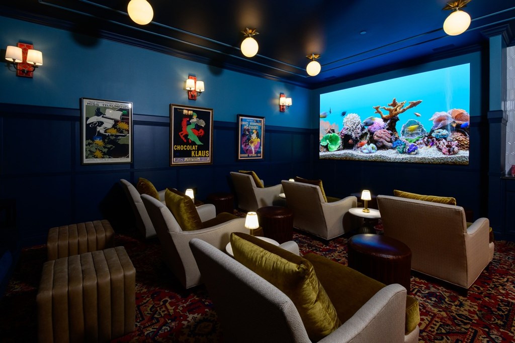 A room with a blue wall and a large screen on the wall.