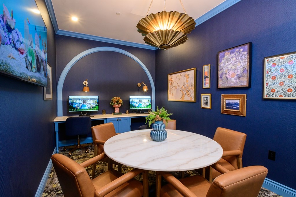 A dining room with a round table and chairs.