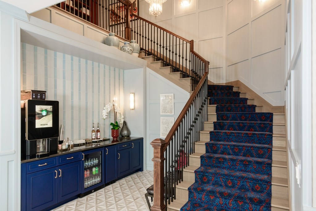 A staircase with a blue carpeted runner and a wooden handrail.