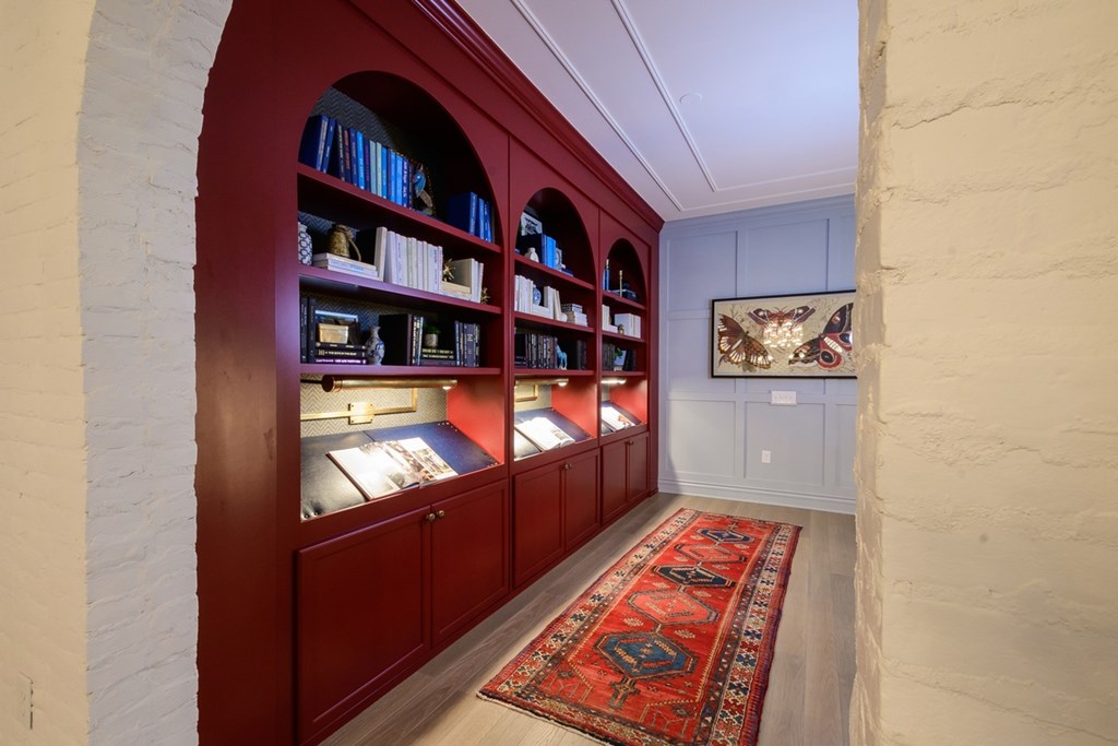 A room with a red carpet and a bookshelf.