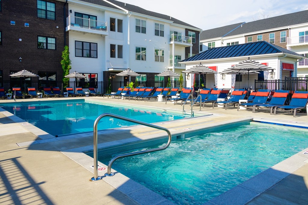 A swimming pool with a slide and sun loungers.