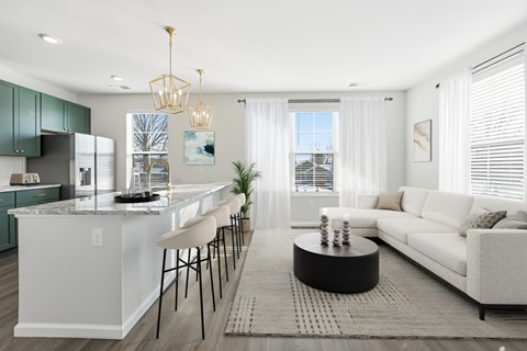 A modern kitchen with a white island and green cabinets.