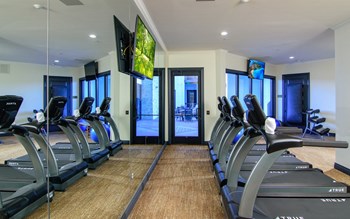 a room filled with cardio equipment and flat screen televisions - Photo Gallery 7