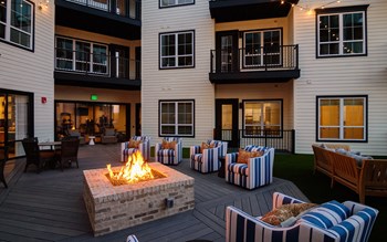 an outdoor patio with a fire pit and chairs - Photo Gallery 2