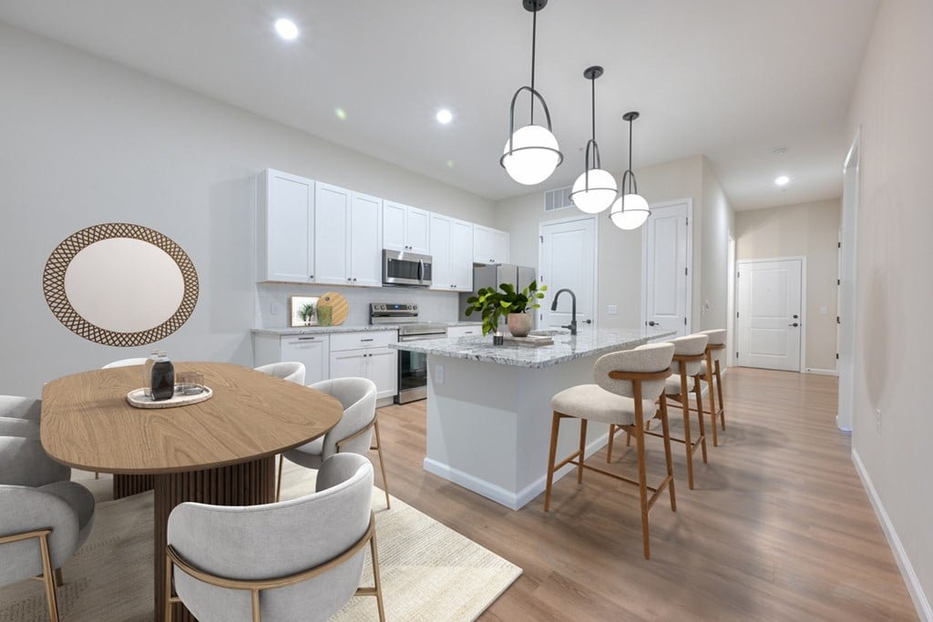 A modern kitchen with a dining table and chairs.