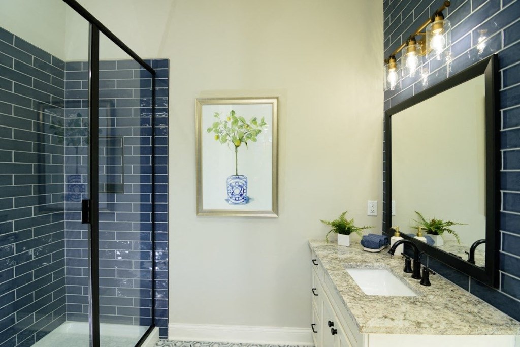 a bathroom with blue subway tile and a blue and white vase on the wall at Fairfax, Grandview, OH