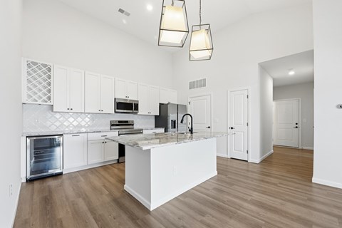A modern kitchen with white cabinets and a central island.