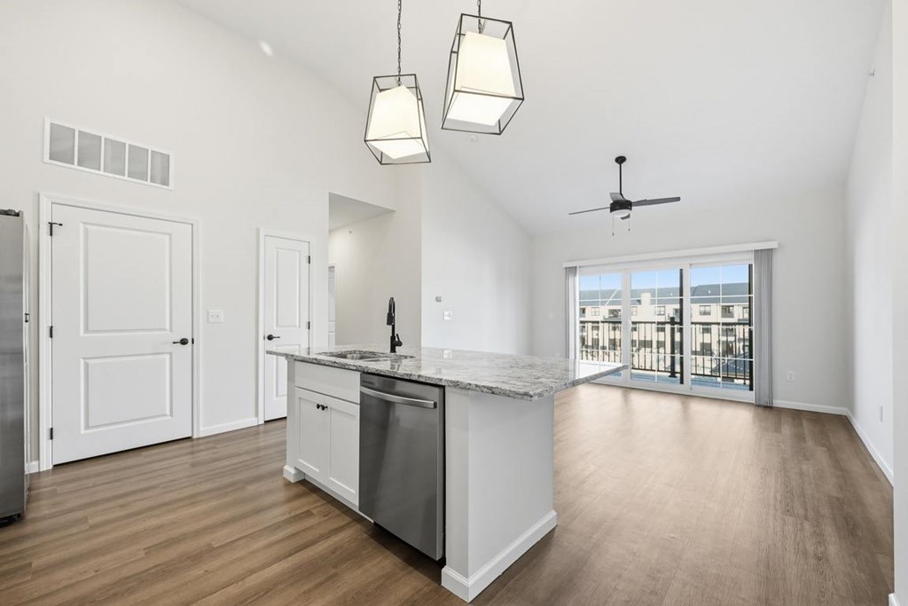 A kitchen with a marble countertop and stainless steel appliances.