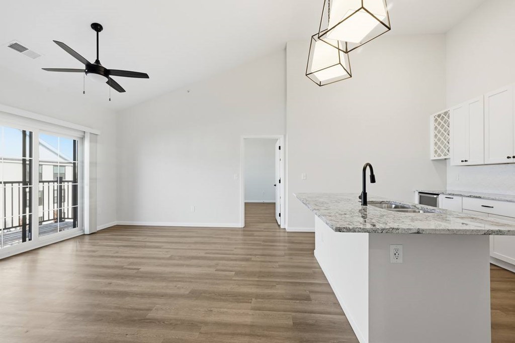 A kitchen with a marble countertop and a ceiling fan.