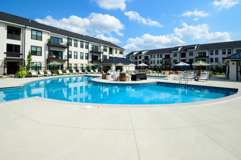 A large swimming pool in front of apartment buildings.