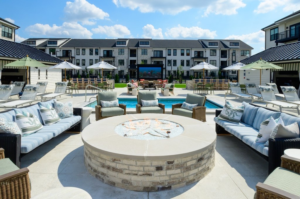 A large outdoor seating area with a fire pit in the center.