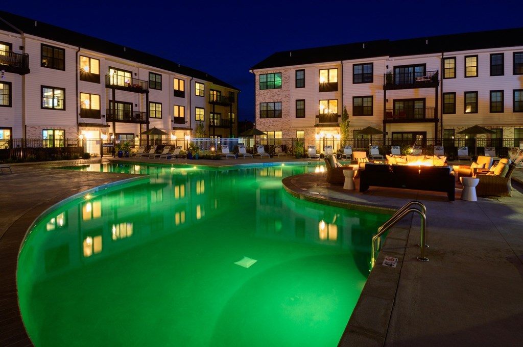 A swimming pool in a courtyard surrounded by apartment buildings.