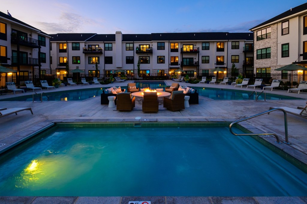 A swimming pool surrounded by lounge chairs and umbrellas at a resort.
