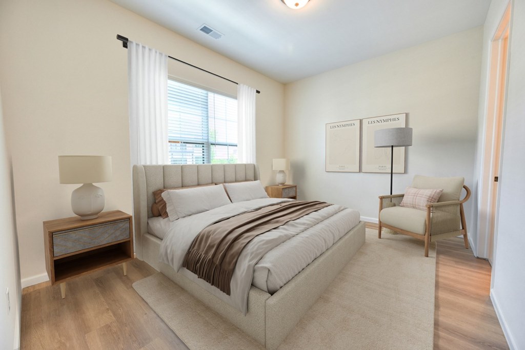 A bedroom with a large bed and a chair.