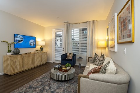 A living room with a sofa, a coffee table, and a painting on the wall.