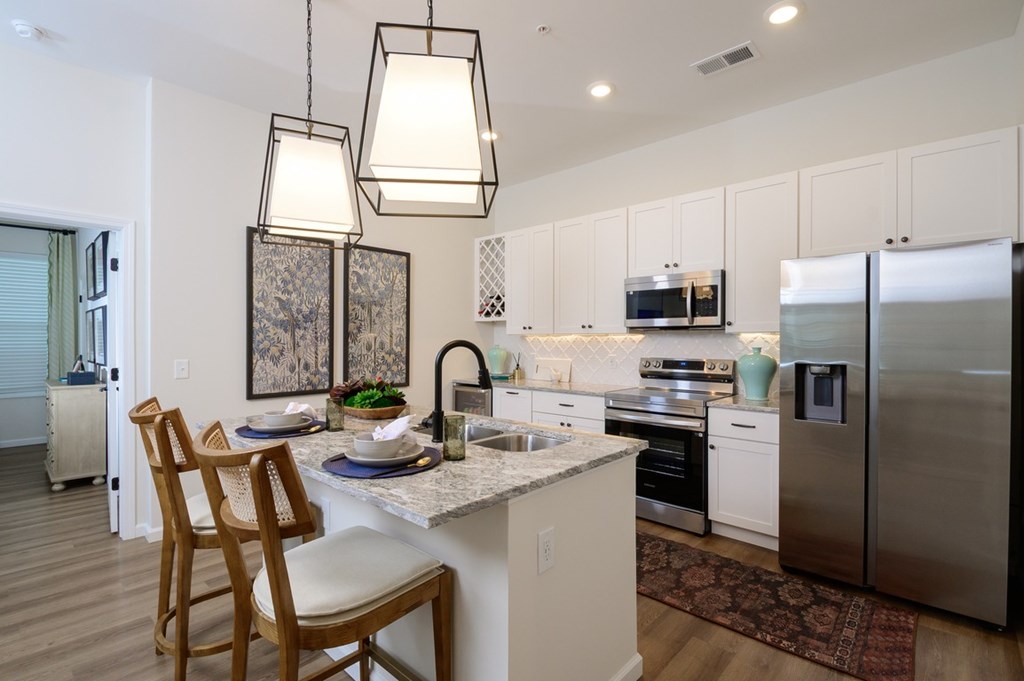 A kitchen with a table and chairs and a refrigerator.