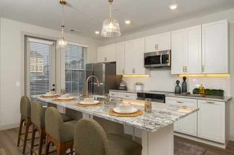 A kitchen with a table and chairs.