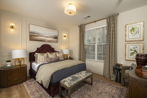 A bedroom with a large bed and a painting on the wall.