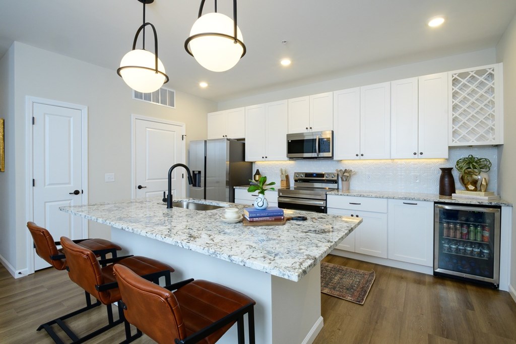 A kitchen with a marble countertop and white cabinets.