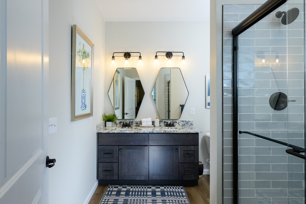 A bathroom with a vanity and a mirror above it.