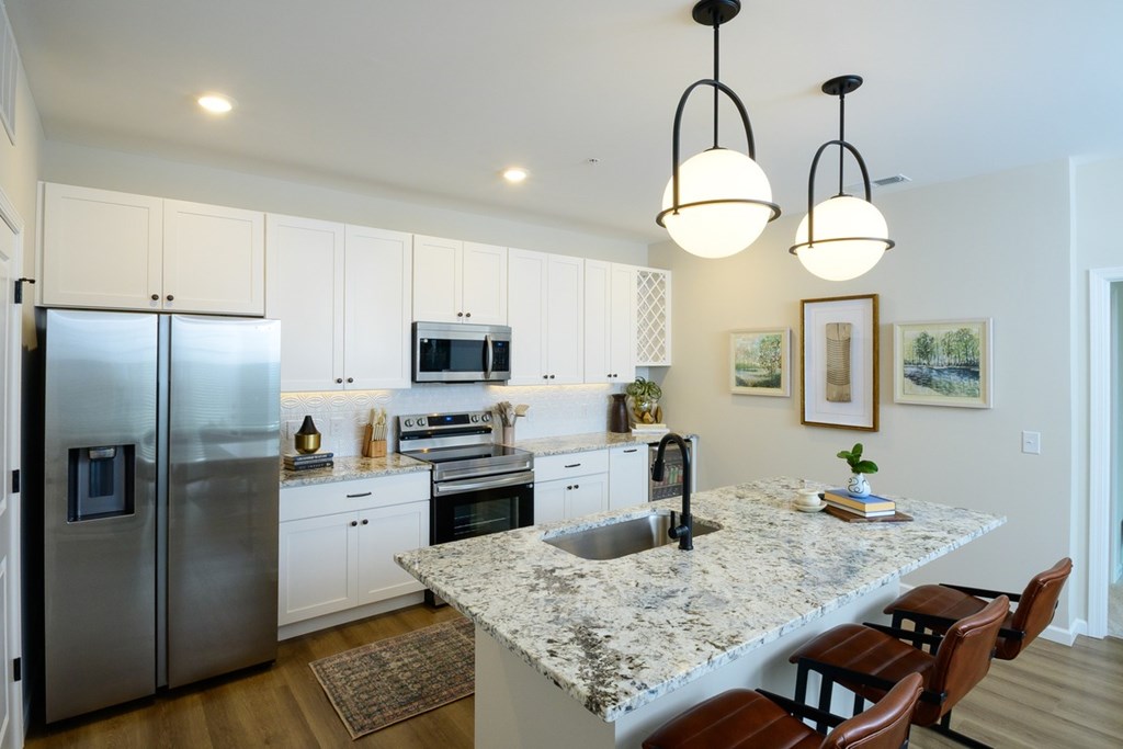 A kitchen with a granite countertop and stainless steel appliances.