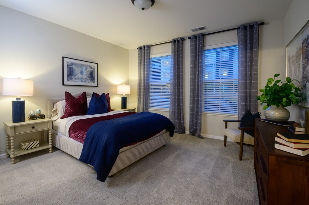 A bedroom with a bed, nightstands, and a plant.