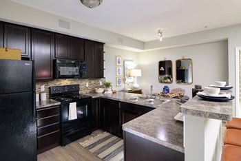 a kitchen with a stove top oven next to a sink at Madison Park, Ohio