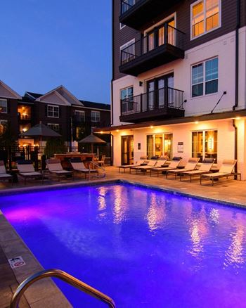 a pool with a blue light at night in front of a building at Kendall Park, Columbus, Ohio