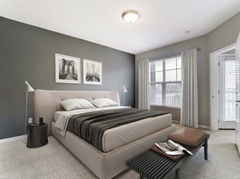a bedroom with a bed and a table in front of a windowat Madison Park Apartments, Columbus, OH, 43214