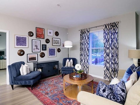 a living room with blue and white furniture and a window