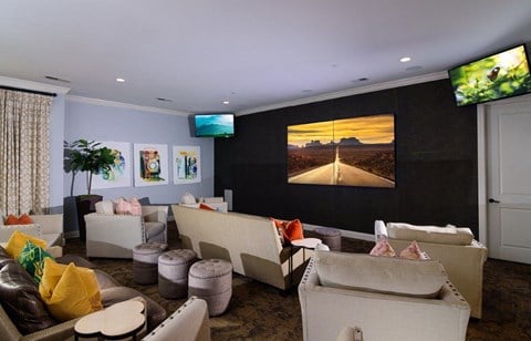 a living room with couches and a tv on the wall