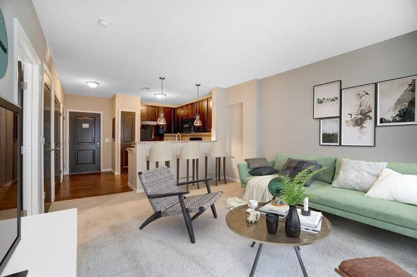 a living room with a couch and chairs and a kitchen in the background - Photo Gallery