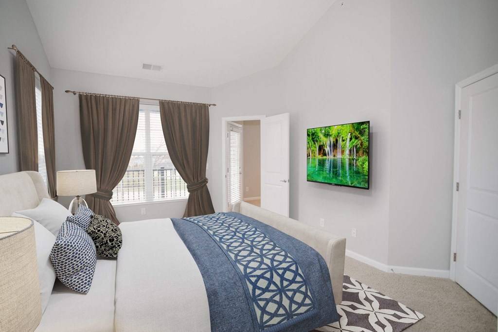 a bedroom with a large bed and a tv on the wall at Kendall Park, Columbus, 43220