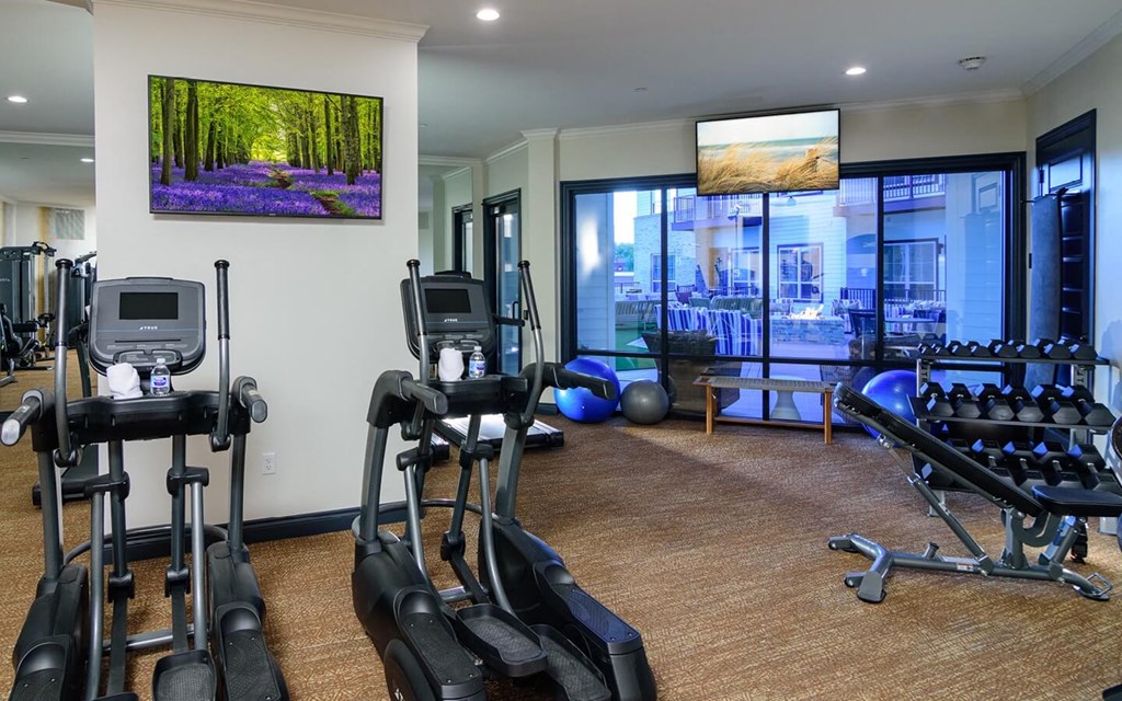 a gym with cardio equipment and a large window  at Essex, Columbus, Ohio