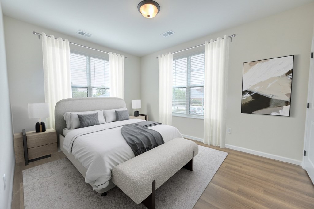 A bedroom with a large bed and a painting on the wall.