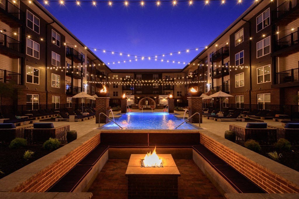 an outdoor pool with a fire pit at nightat Taylor House Apartments, Columbus, OH, 43214