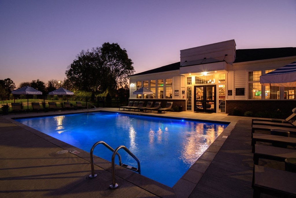 the pool is lit up at night in the backyard of a home at Elan Park, Columbus