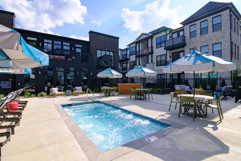 a swimming pool in a courtyard with tables and umbrellas at Dalton, New Albany, OH