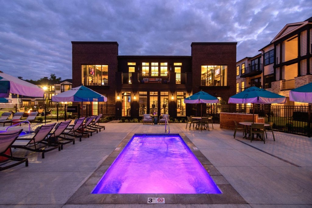 the pool is lit up at night in front of a building at Dalton, New Albany, OH