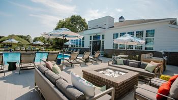 a patio with couches and umbrellas and a fire pit in front of a building at Elan Park, Ohio, 43231
