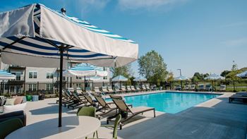 a swimming pool with chaise lounge chairs and umbrellas at Elan Park, Ohio