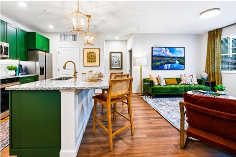 A kitchen with green cabinets and a white countertop.