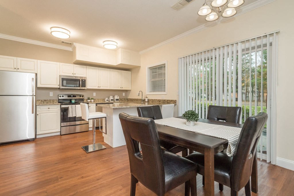 A kitchen with a table and chairs.