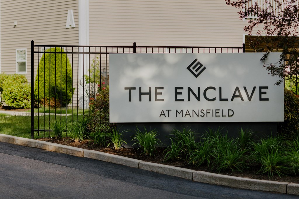 A sign that says "The Enclave at Mansfield" is displayed in front of a building.