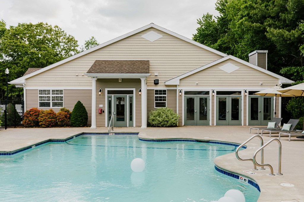 A house with a pool in front of it.