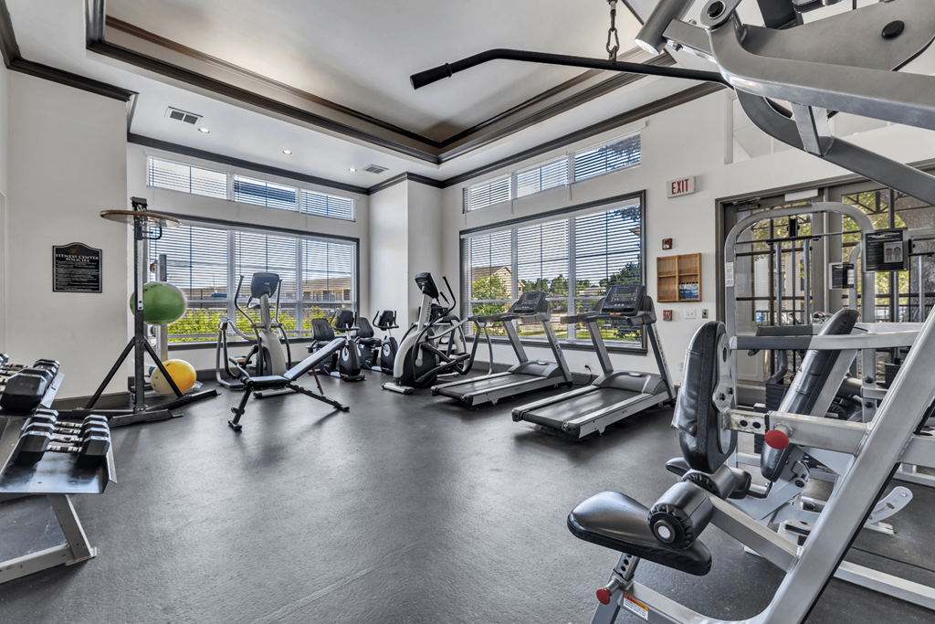 a gym with weights and other exercise equipment and windows