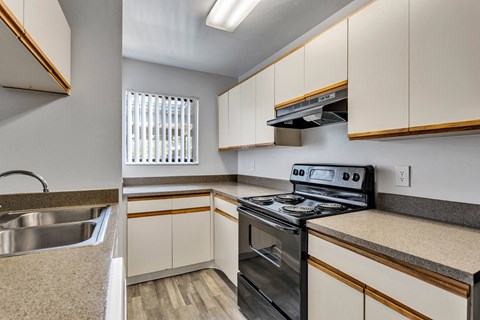 the kitchen of a home with white cabinets and stainless steel appliances