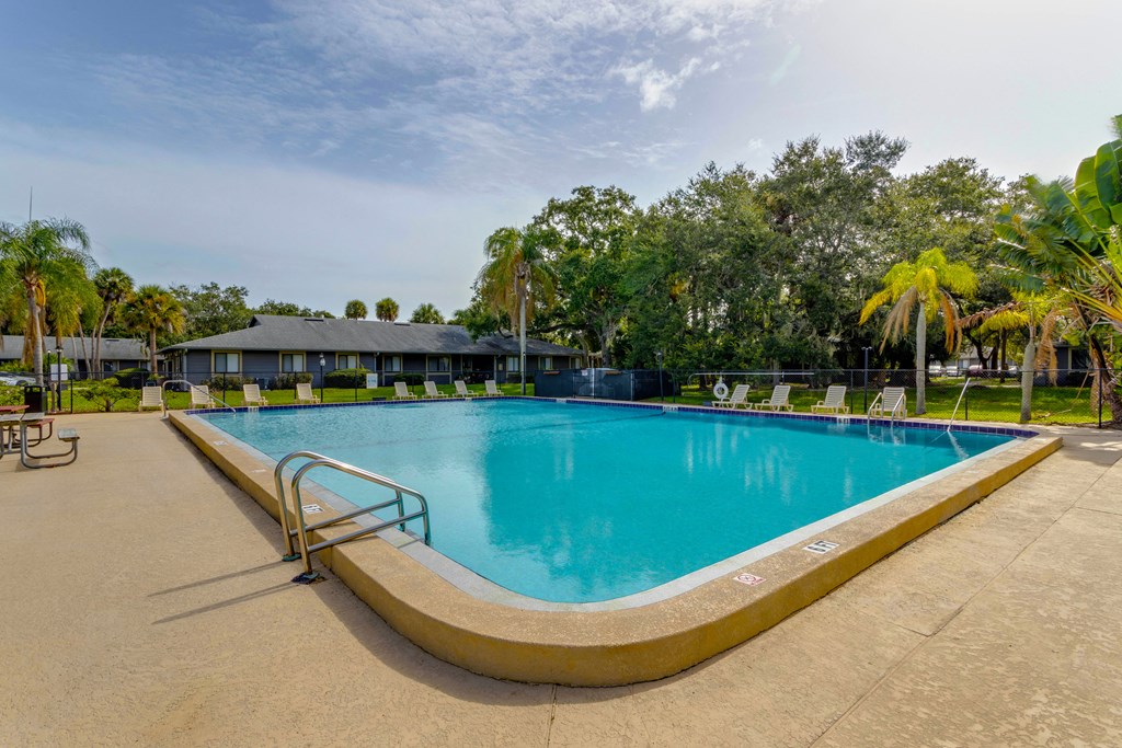 a swimming pool at a resort with a building in the background